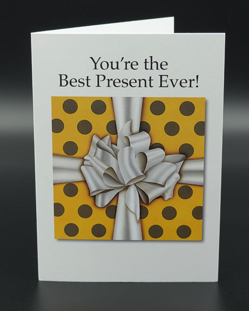 Greeting card with yellow polka dot pattern and white bow, featuring text 'You're the Best Present Ever!' on a white background.